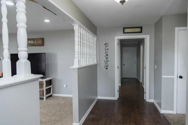a view of a hallway with front door and wooden floor