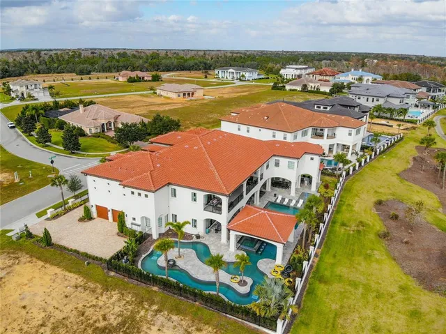 an aerial view of residential houses with outdoor space and ocean view