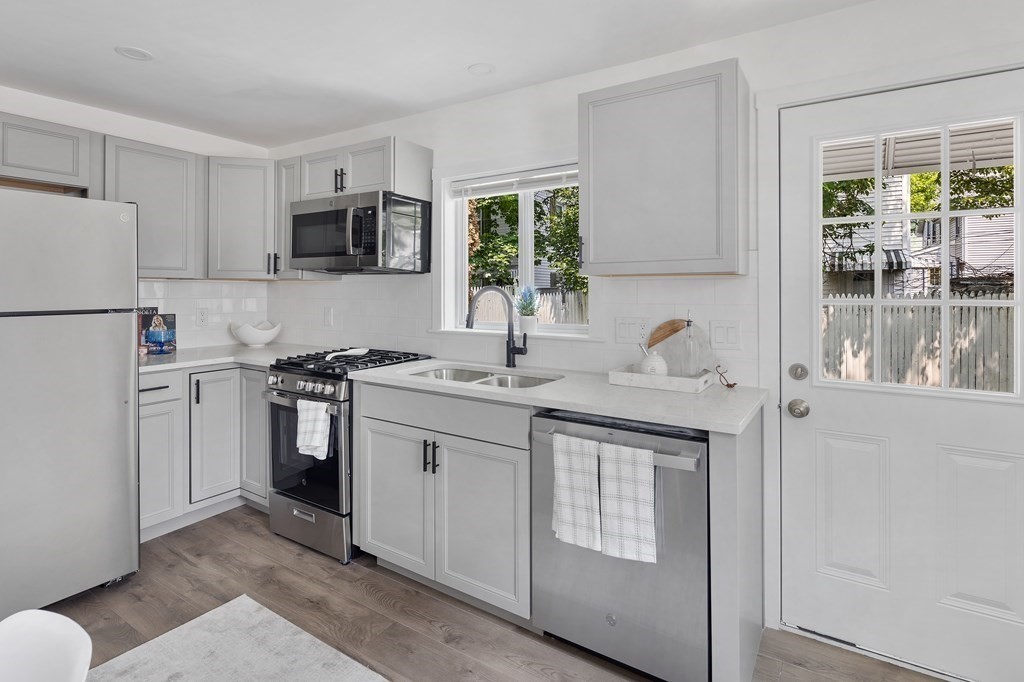 a kitchen with stainless steel appliances granite countertop a sink stove and refrigerator