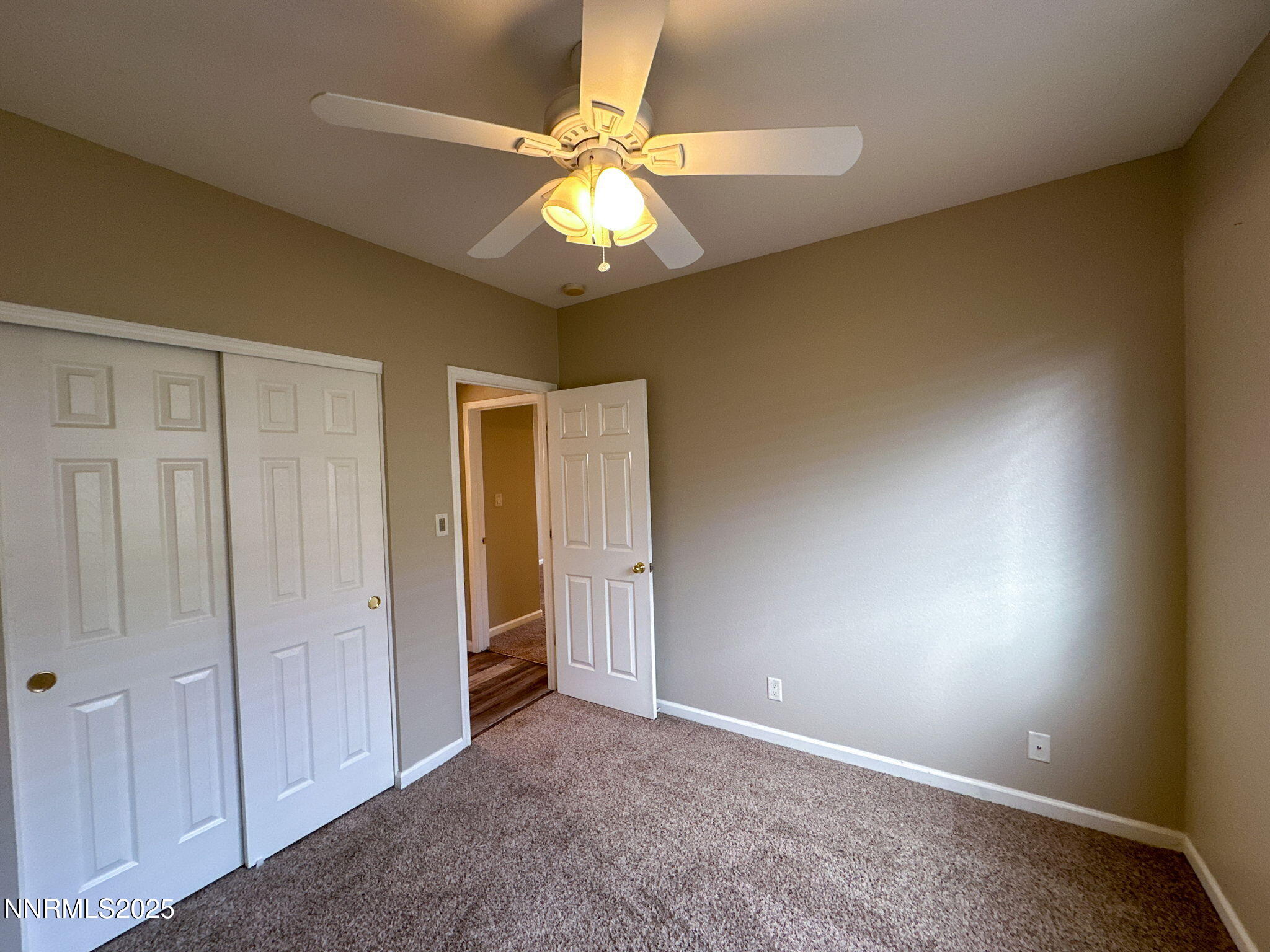 2185 Eagle Greens Drive Reno, NV 89521 - Photo 9 of 22 an empty room with a chandelier fan and a window