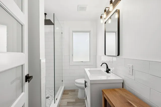 a bathroom with a sink a toilet and shower