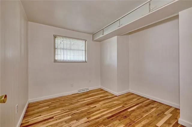 a view of a room with wooden floor and bench