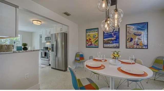 a view of a dining room with furniture a chandelier and wooden floor