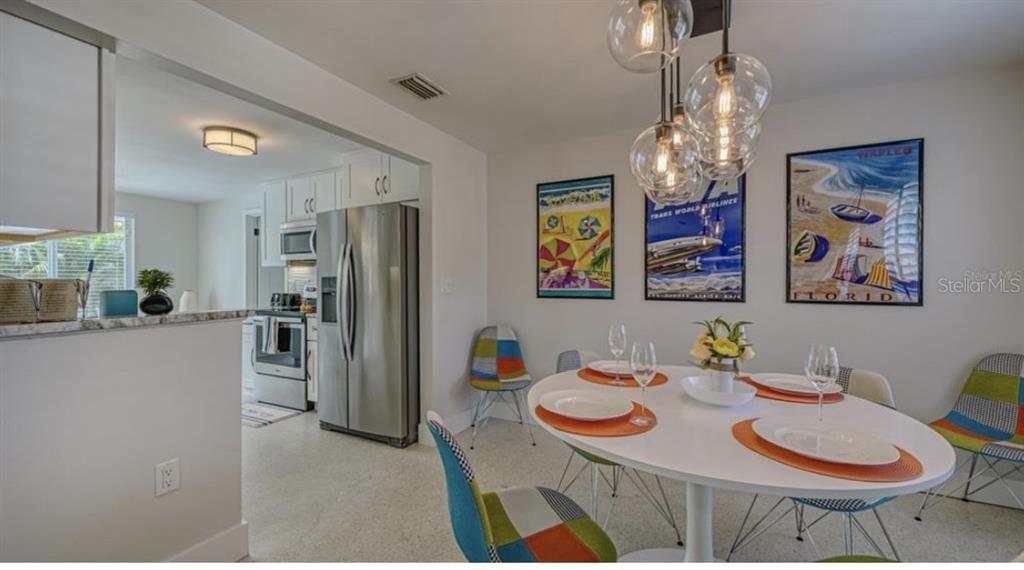 2904 Homasassa Road Sarasota, FL 34239 - Photo 10 of 37 a view of a dining room with furniture a chandelier and wooden floor