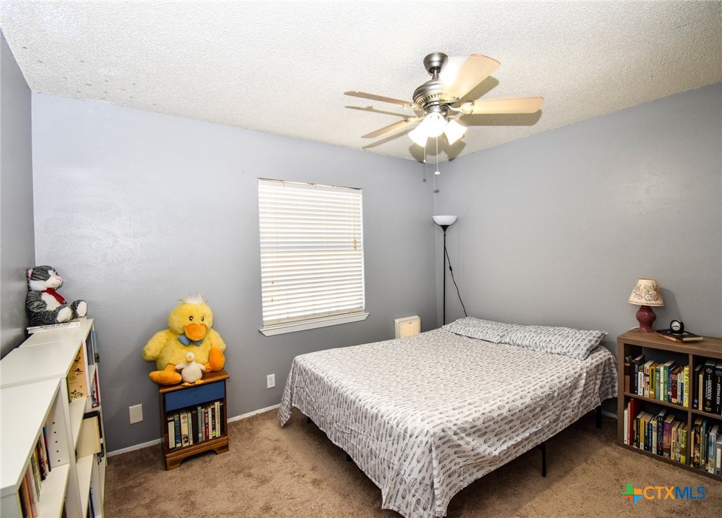 2202 Stagecoach Trail Temple, TX 76502 - Photo 16 of 27 a bedroom with a bed and a chandelier