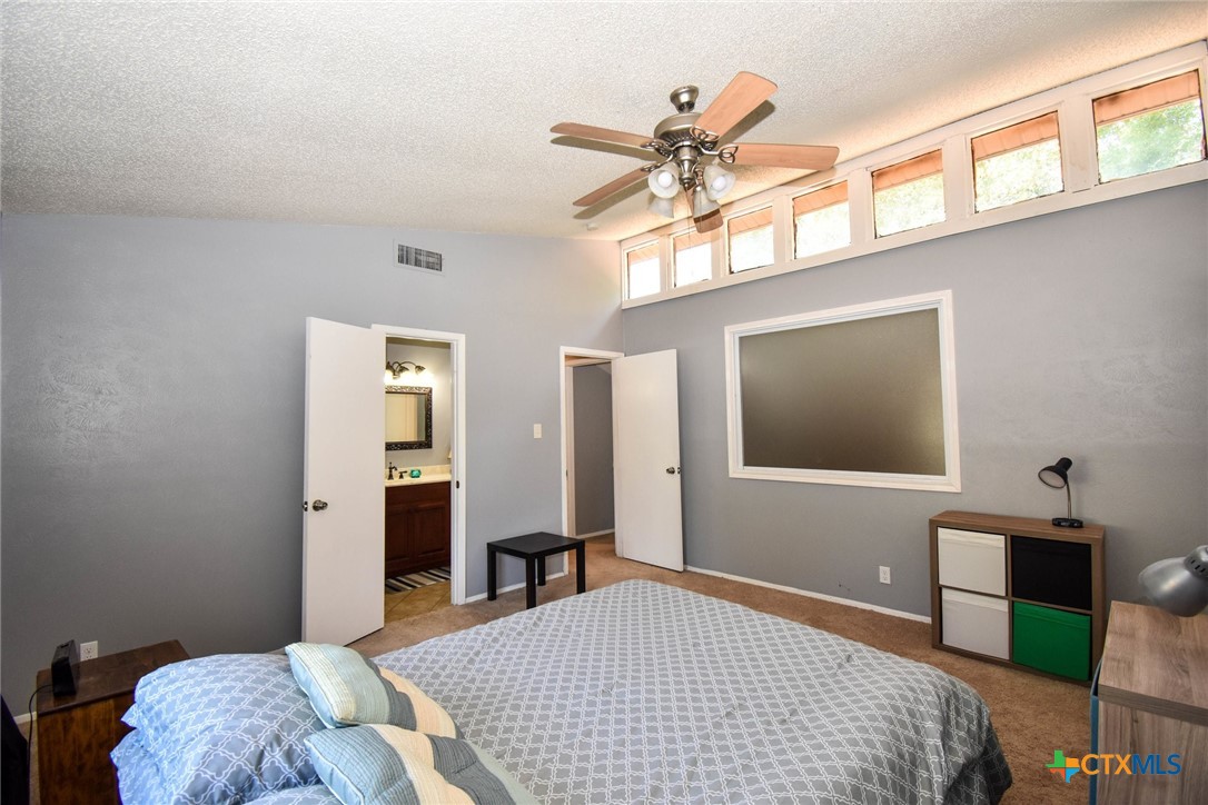 2202 Stagecoach Trail Temple, TX 76502 - Photo 18 of 27 a bedroom with a bed and a chandelier