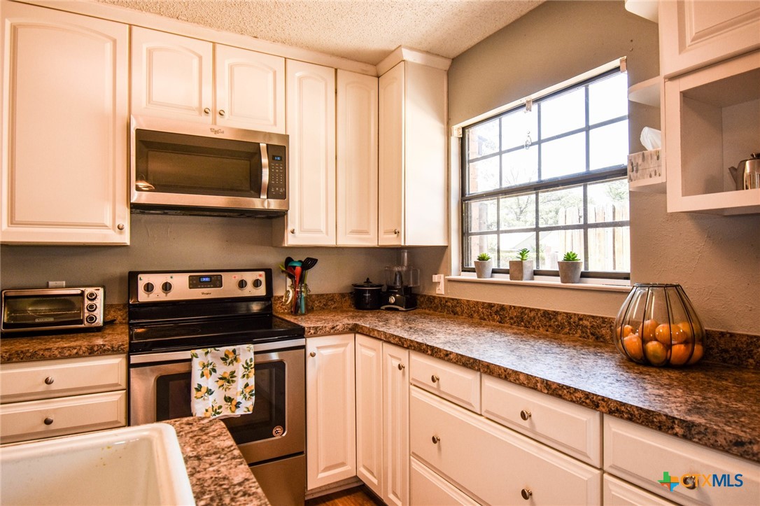 2202 Stagecoach Trail Temple, TX 76502 - Photo 6 of 27 a kitchen with stainless steel appliances a stove a microwave and cabinets