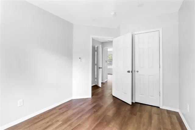 an empty room with wooden floor and closet