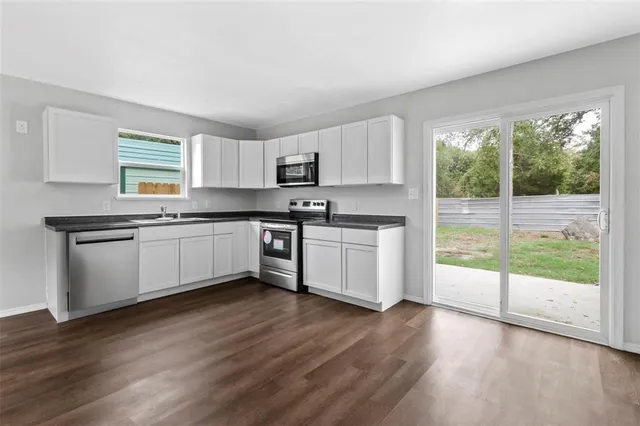 a view of a kitchen with a sink wooden floor and a window