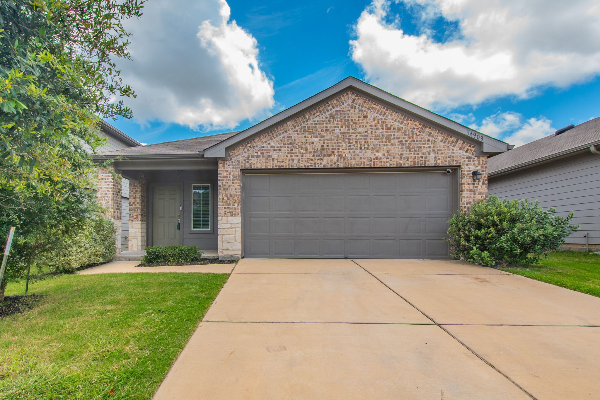 A classic brick and stone facade welcomes you to this inviting home with a well-maintained lawn.