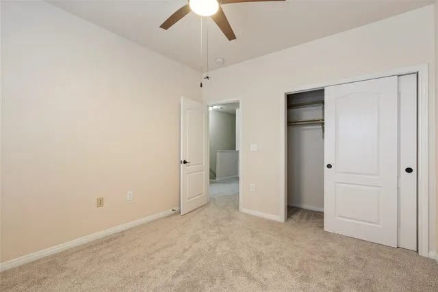 an empty room with fan and entrance