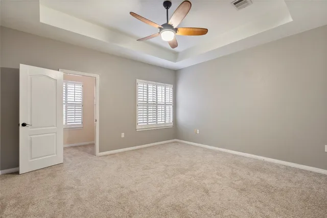 an empty room with windows and fan