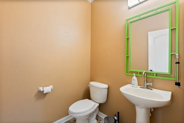 a bathroom with a sink a toilet and mirror
