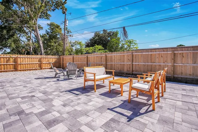 a backyard of a house with fountain table and chairs