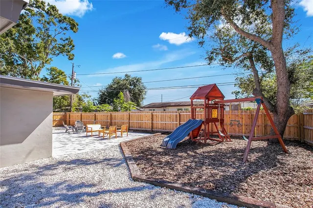 a backyard of a house with barbeque oven table and chairs