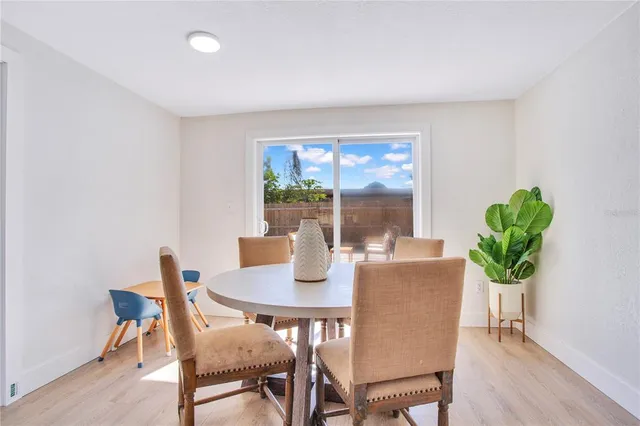 a dining room with furniture potted plants and wooden floor