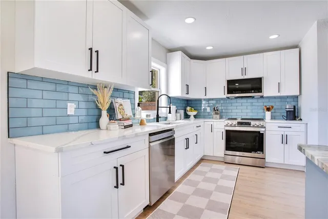 a kitchen with cabinets stainless steel appliances and a sink