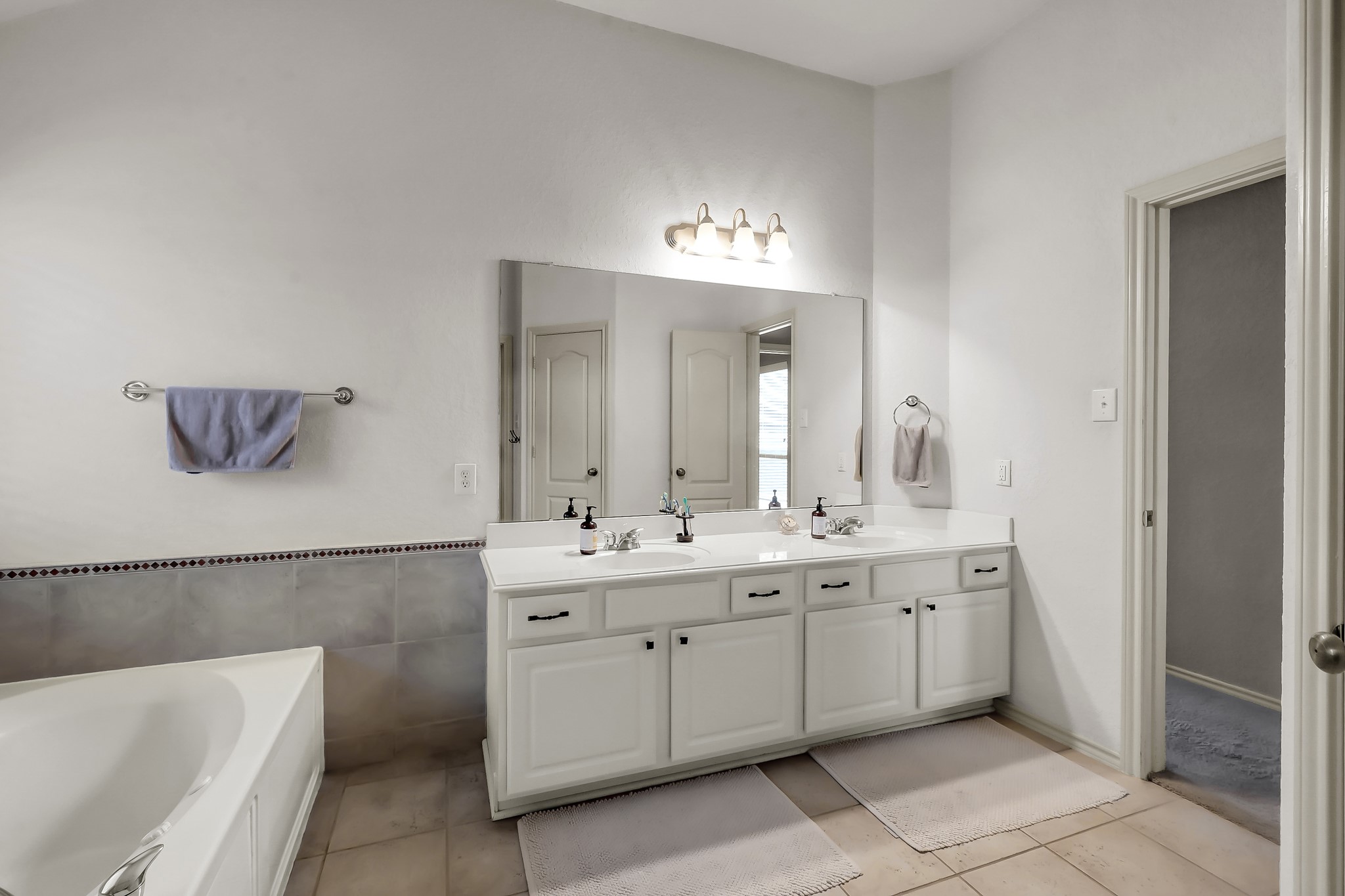 2318 Caroline Park Lane Spring, TX 77386 - Photo 28 of 38 a spacious bathroom with a double vanity sink mirror and bathtub