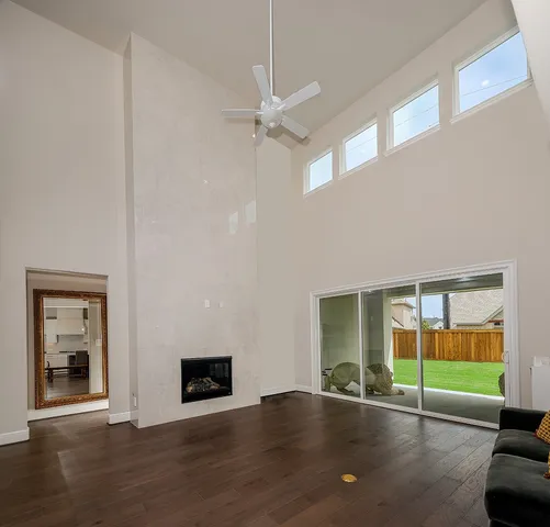 an empty room with windows and fireplace
