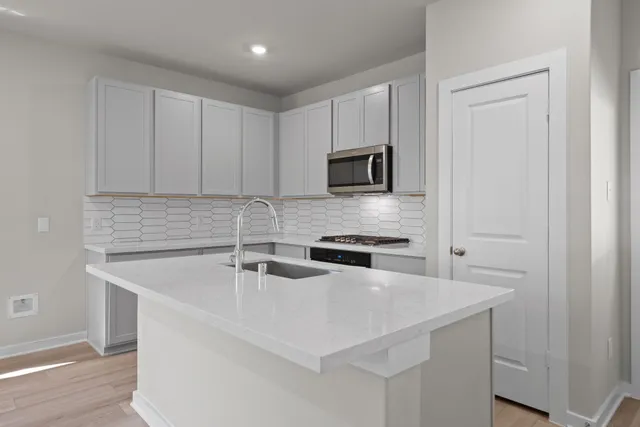 a kitchen with sink a microwave a stove and refrigerator