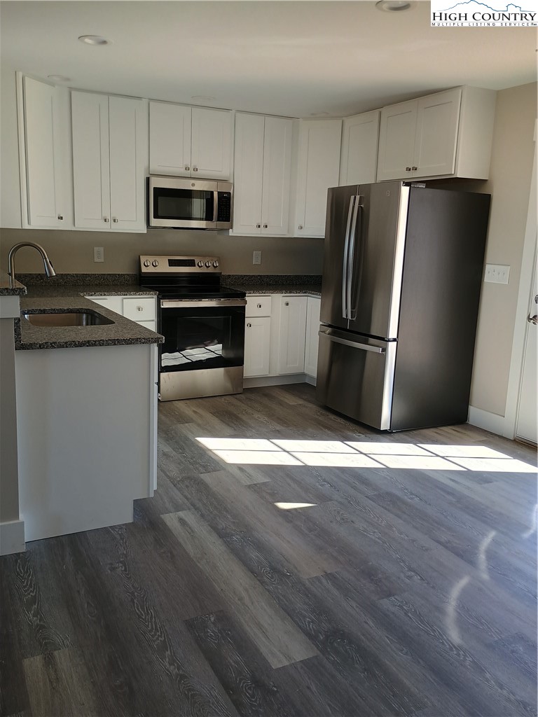 90 Millards Way Sparta, NC 28675 - Photo 3 of 8 a kitchen with granite countertop a refrigerator and a stove top oven