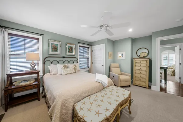 a bedroom with a bed a chandelier and dresser