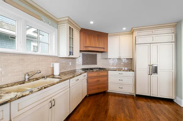 a kitchen with granite countertop white cabinets and white appliances