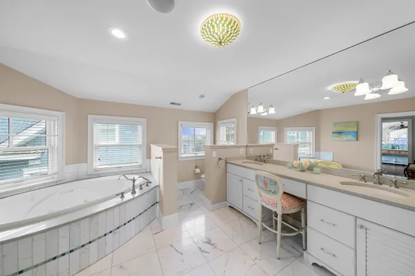 a large bathroom with a granite countertop sink mirror and a bathtub