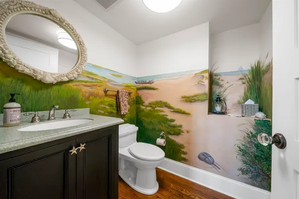 a bathroom with a granite countertop sink mirror vanity and toilet