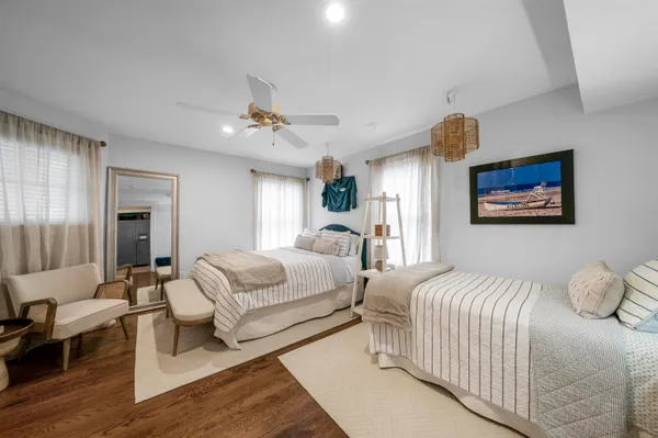 a spacious bedroom with two beds and painting on the wall