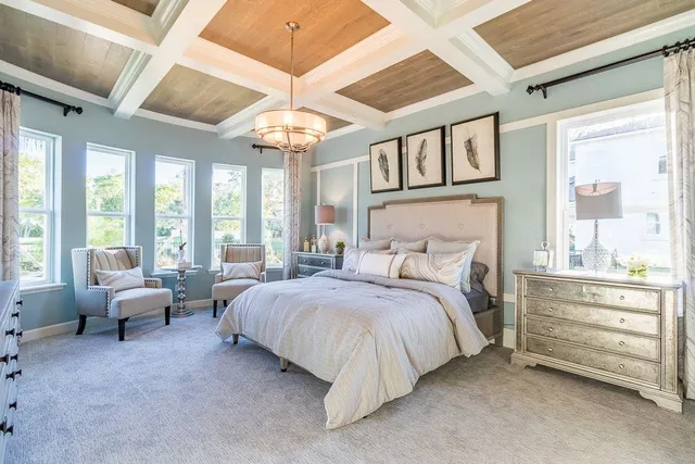 a spacious bedroom with a bed and a chandelier