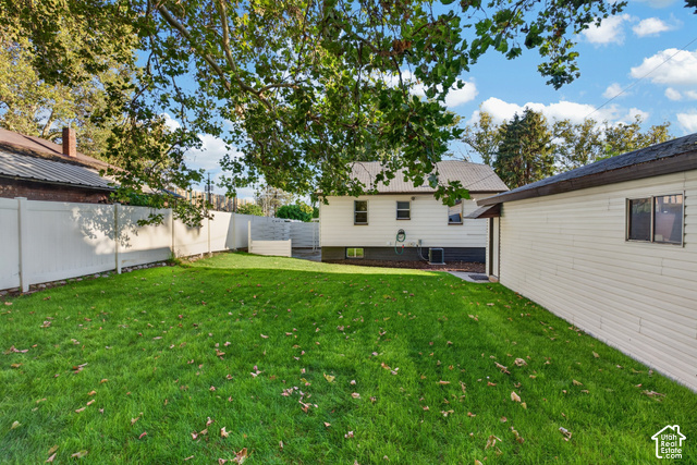 147 Center Street Clearfield, UT 84015 - Photo 12 of 55 Expansive backyard featuring a manicured lawn, mature shade trees, and fenced perimeter