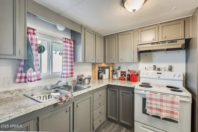 a kitchen with a sink stove top oven and cabinets