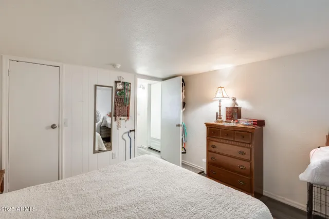 a bedroom with a bed and a lamp on dresser