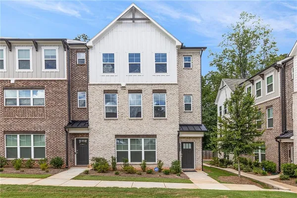 a front view of a house with garden and trees