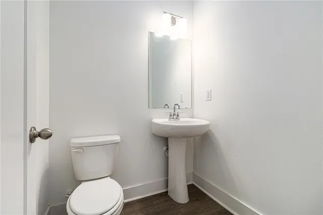 a bathroom with a sink toilet and a mirror