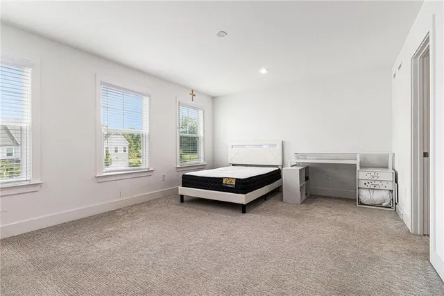 a spacious bedroom with a bed and a window