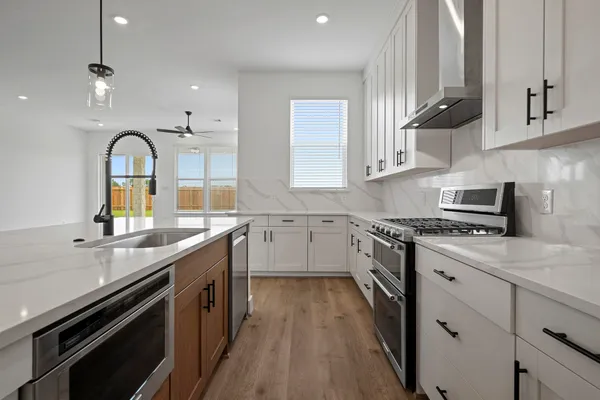 a kitchen with stainless steel appliances granite countertop a sink a stove and cabinets