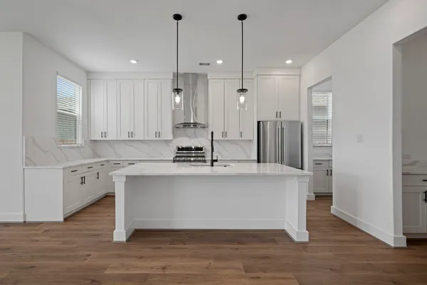a view of kitchen with stainless steel appliances granite countertop cabinets and wooden floor
