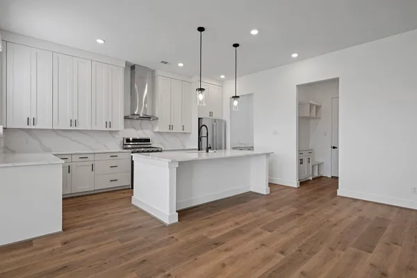 a kitchen with white cabinets and stainless steel appliances
