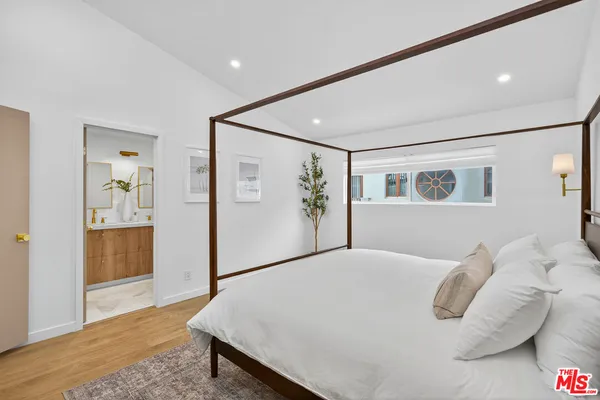 a bedroom with a large bed and a chandelier