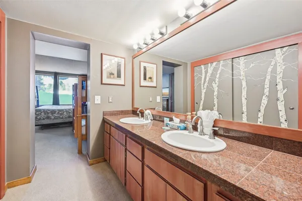 a en suite bathroom with a granite countertop sink and a mirror