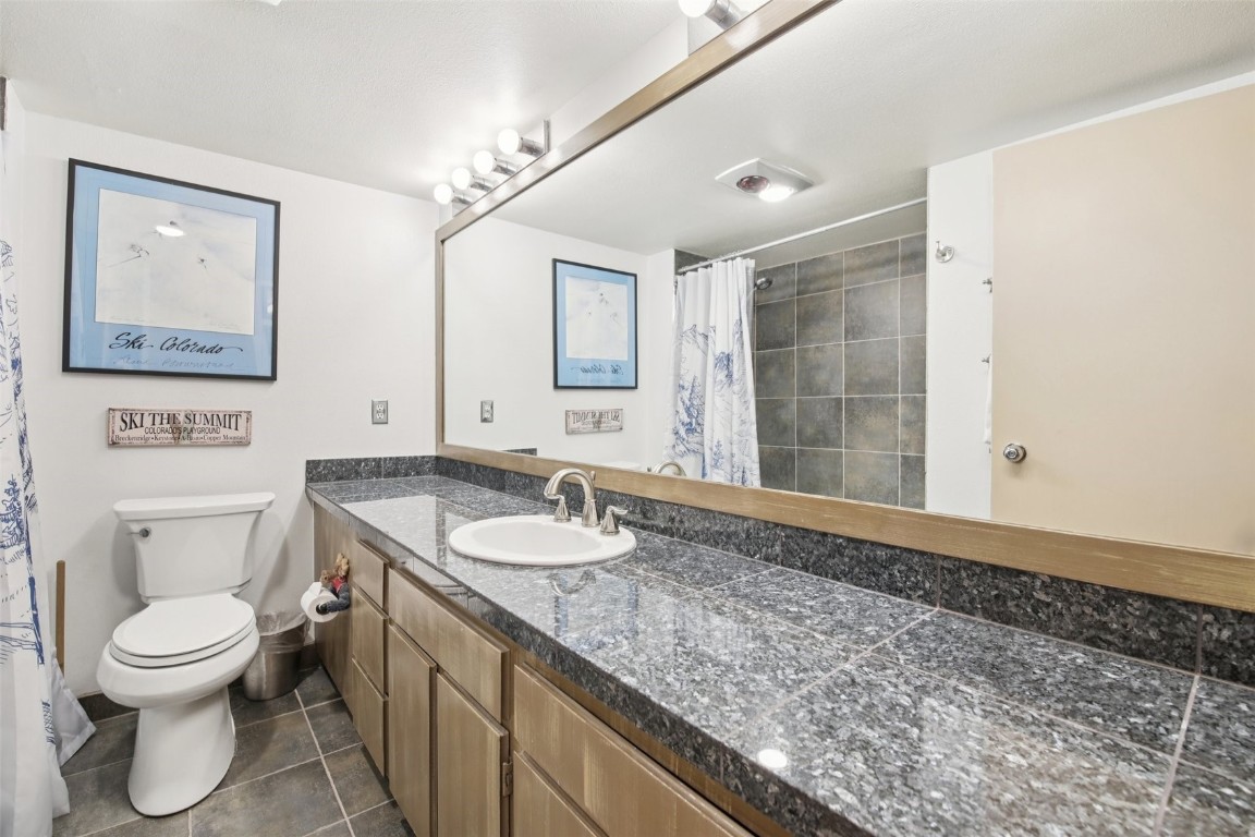 22340 Highway 6, Unit 1788 Keystone, CO 80435 - Photo 17 of 21 a bathroom with a granite countertop sink a toilet and a mirror