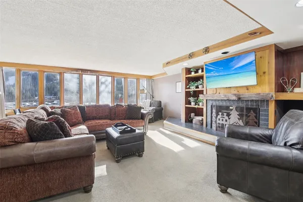 a living room with fireplace furniture and a large window