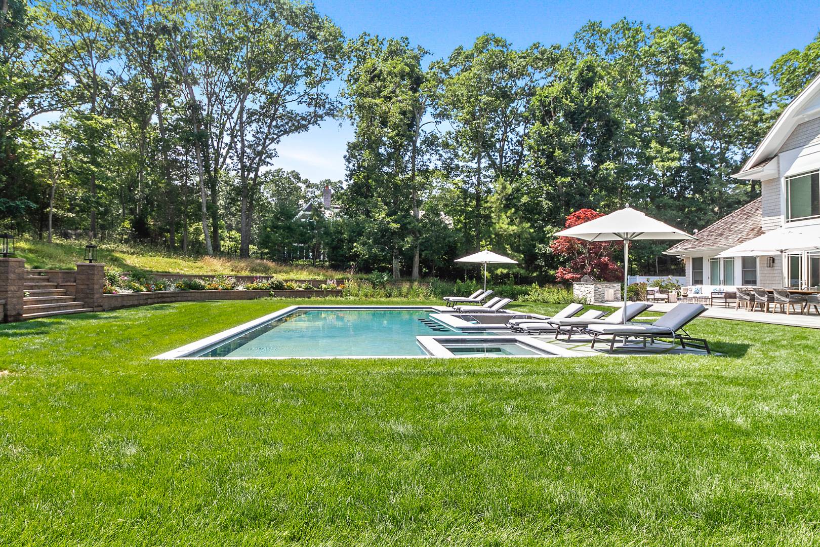 8 Shady Pth Bridgehampton, NY 11963 - Photo 4 of 30 a view of a swimming pool with lawn chairs under an umbrella