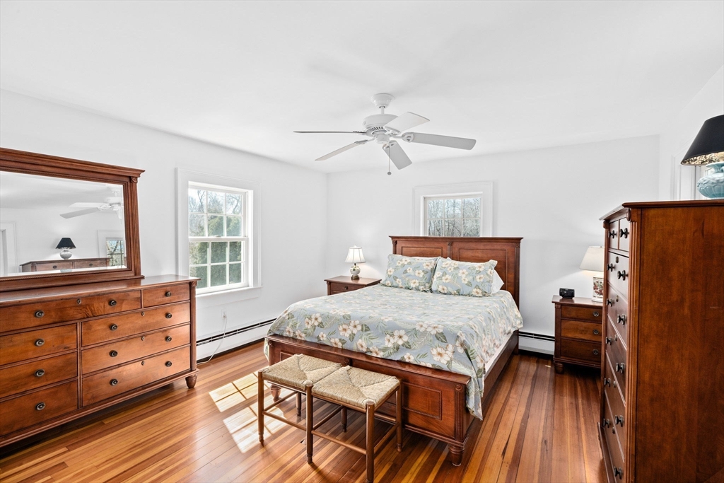 59 Gannett Road Scituate, MA 02066 - Photo 15 of 40 a bedroom with a bed and wooden floor