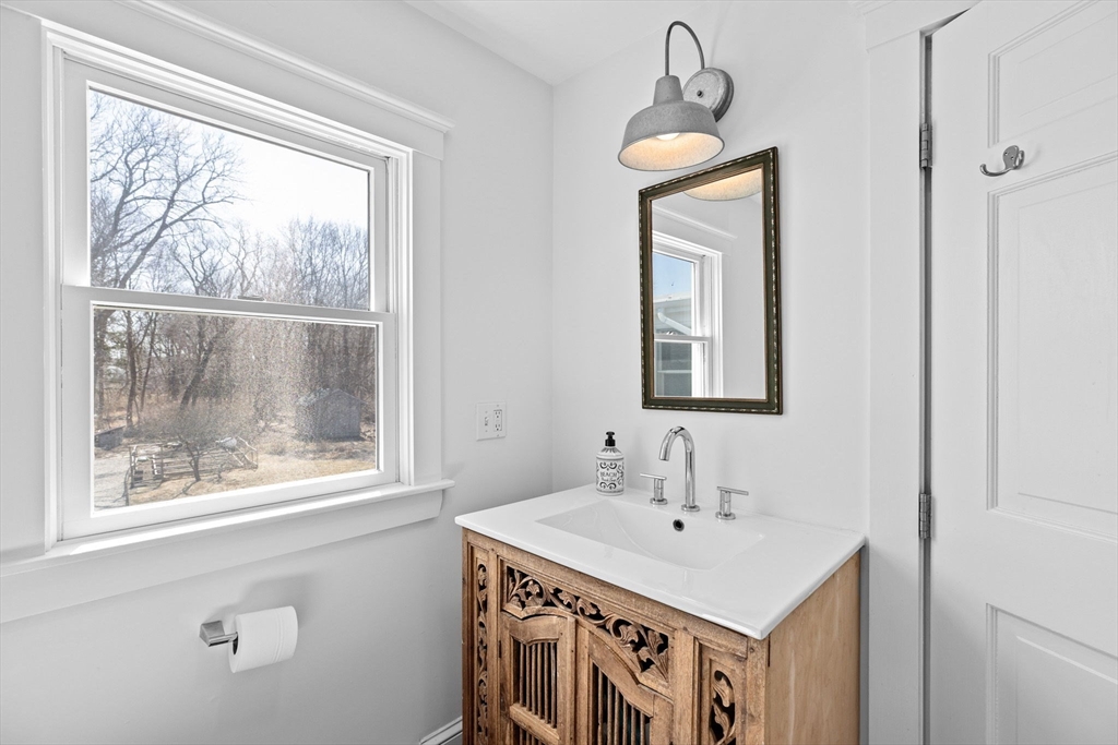 59 Gannett Road Scituate, MA 02066 - Photo 18 of 40 a bathroom with a sink a window and a mirror