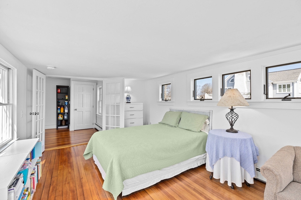 59 Gannett Road Scituate, MA 02066 - Photo 20 of 40 a bedroom with a bed and wooden floor