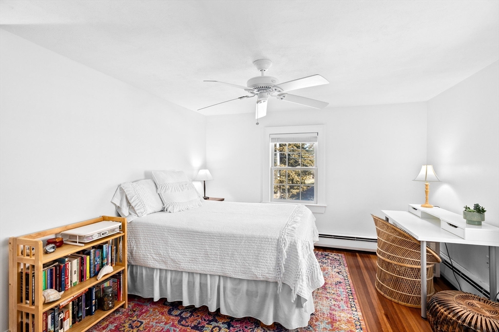 59 Gannett Road Scituate, MA 02066 - Photo 23 of 40 a bedroom with a bed and a chandelier
