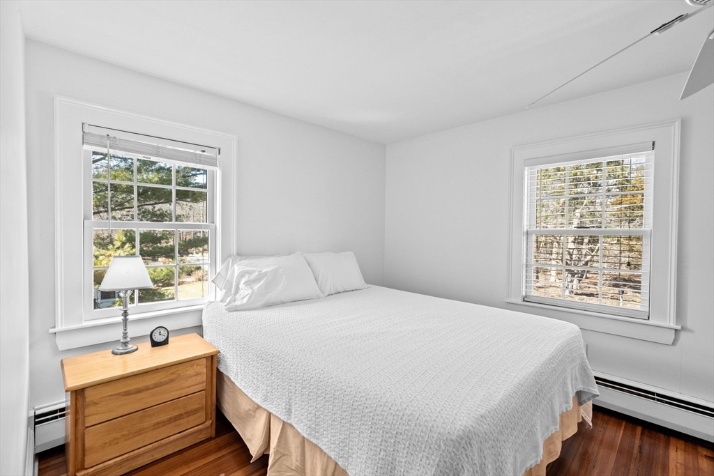 59 Gannett Road Scituate, MA 02066 - Photo 24 of 40 a bedroom with a bed and a table lamp